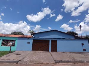a house with a garage with a sky at Casa Simples e Agradável da Lu in Alto Paraíso de Goiás