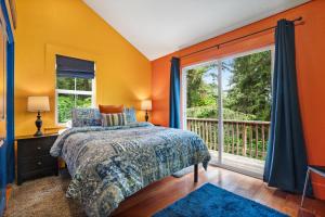 um quarto com paredes cor de laranja, uma cama e uma janela em Stylish Cabin em Orick