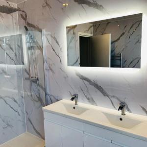 a white bathroom with a sink and a mirror at The Whitehouse in Blackpool