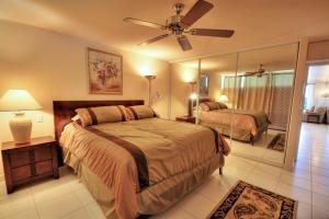 une chambre avec deux lits et un ventilateur de plafond dans l'établissement Kahana Reef #116, à Kahana 8 autres photos