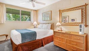 a bedroom with a bed and a dresser and a mirror at Exquisite Honokowai Palms Unit #A-7 in Kahana