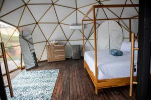 a bedroom with a canopy bed in a yurt at Elysium Glamping in Guatapé