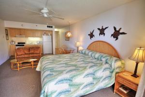 a bedroom with a bed and a kitchen at Royal Kahana #319 in Kahana