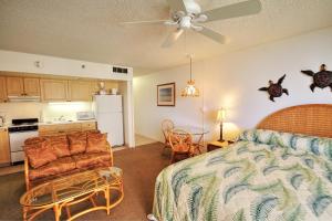 a bedroom with a bed and a kitchen with a refrigerator at Royal Kahana #319 in Kahana +8 photos
