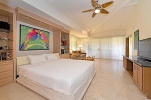 a bedroom with a white bed and a tv at Maui Kaanapali Villas #D271 in Lahaina