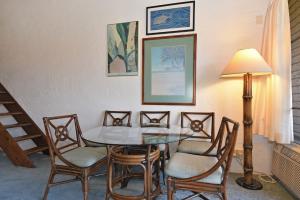 a dining room with a table and chairs and a lamp at Papakea Condo Unit D402 in Kahana