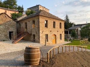 een oud stenen gebouw met een vat ervoor bij Agriturismo Il Mulino della Rocca in Berceto