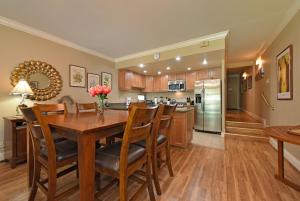 a kitchen and dining room with a wooden table and chairs at Hale Mahina B101 in Kahana