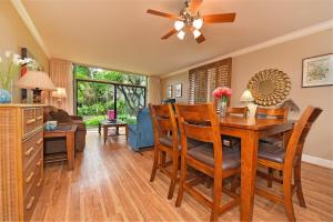 a dining room with a table and chairs and a ceiling fan at Hale Mahina B101 in Kahana