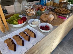 uma mesa com biscoitos e tigelas de frutas e pão em Agriturismo Il Mulino della Rocca em Berceto