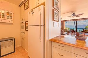 a kitchen with a white refrigerator and a dining room at Valley Isle #205 in Kahana