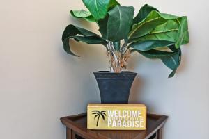 a plant in a vase on a table with a sign at Mahana Resort #1204 in Kahana