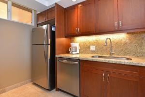 a kitchen with wooden cabinets and a stainless steel refrigerator at Mahana Resort #906 in Kahana