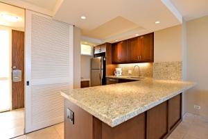 a kitchen with a granite counter top and wooden cabinets at Mahana Resort #906 in Kahana