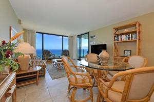 a living room with a glass table and chairs at Mahana Resort #906 in Kahana