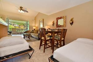 um quarto com 2 camas, uma mesa e cadeiras em Maui Kaanapali Villas #B233 em Lahaina