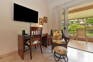 sala de estar con escritorio, TV y silla en Maui Kaanapali Villas #B233 en Lahaina