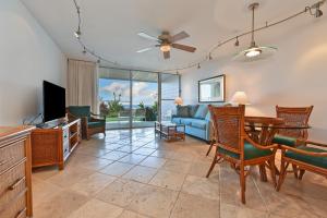 a living room with a couch and a table and chairs at Makani Sands #102 in Kahana