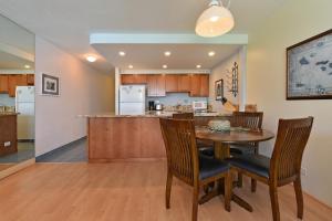 une cuisine et une salle à manger avec une table et des chaises dans l'établissement Kahana Reef #414, à Kahana