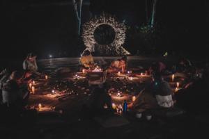 a group of people sitting around a circle with candles at KANTU GARDEN LODGE in Moyobamba +69 photos