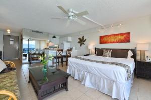 a bedroom with a large bed and a living room at Valley Isle 1206 in Kahana