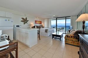 a hotel room with a bed and a kitchen and a living room at Valley Isle 1206 in Kahana