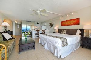 a bedroom with a bed and a living room with a couch at Valley Isle 1206 in Kahana