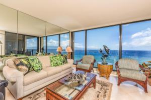 a living room with a couch and chairs and windows at Mahana Resort #1017 in Kahana