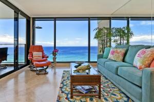 a living room with a blue couch and ocean views at Mahana Resort #1205 in Kahana