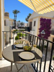 una mesa con platos y copas de vino en el balcón en Marisol Apartment Vera Playa Andalusia 150 m from the Beach, en Vera