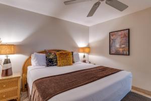 um quarto com uma cama e uma ventoinha de tecto em Papakea #G106 em Kahana