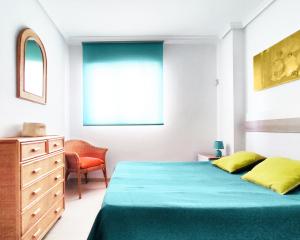 a bedroom with a bed and a dresser and a window at Playa Dorada VISTAS al MEDITERRANEO in El Borseral