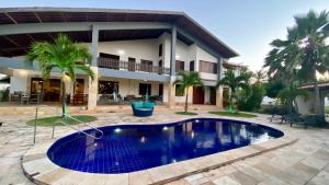 a house with a swimming pool in front of a house at Lineup Kite & Surf House in Taíba