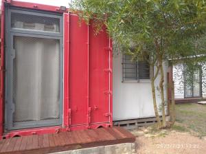 a red house with a window next to a tree at Tu lugar de relax! Se reserva solo con seña in Guazuvira