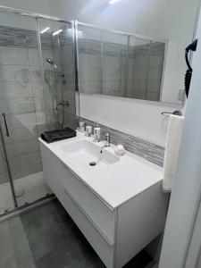 Casa Dei Cavalieri في كوزنسا: حمام أبيض مع حوض ودش