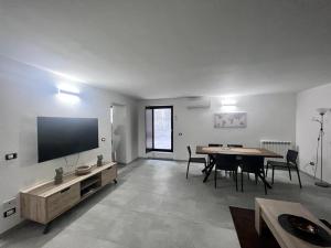 a large living room with a table and a television at Casa Dei Cavalieri in Cosenza