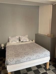 1 dormitorio con cama con colcha y almohadas blancas en Gîte Alet les bains, en Alet-les-Bains