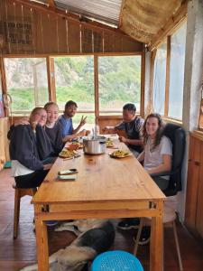 a group of people sitting around a wooden table at The Hub - Centro Sakbe in San Juan La Laguna