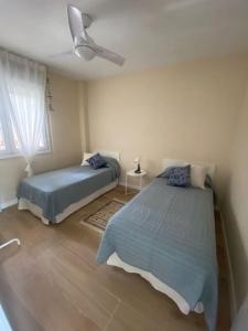 1 Schlafzimmer mit 2 Betten und einem Deckenventilator in der Unterkunft Vacaciones en la Costa del Sol in Torremolinos