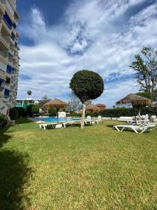 ein Park mit Tischen, Stühlen und einem Baum in der Unterkunft Vacaciones en la Costa del Sol in Torremolinos