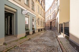 an empty street in a city with buildings at Old town studio on Mucenieku street in Riga