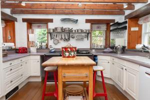 a kitchen with white cabinets and a wooden counter top at The Polchar - Aviemore in Aviemore