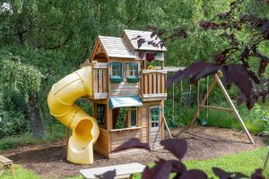 a small wooden play house with a slide at The Polchar - Aviemore in Aviemore