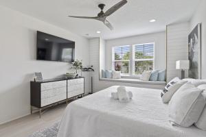 a white bedroom with a bed with a ceiling fan at The White House Island,Beach,Hot Tub,Downtown in Saint Augustine