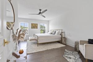 a white bedroom with a bed and a couch at The White House Island,Beach,Hot Tub,Downtown in St. Augustine