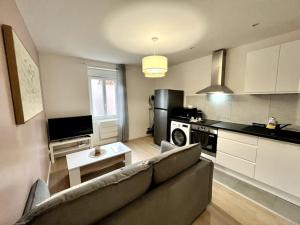ein Wohnzimmer mit Couch und Küche in der Unterkunft Superbe appartement au Centre ville/Balcon in Valence