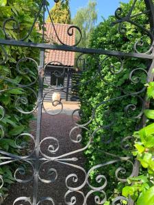 a gate to a garden with a bench and some bushes at Newly converted 2 storey, 2 bedroom, barn in Long Melford in Long Melford
