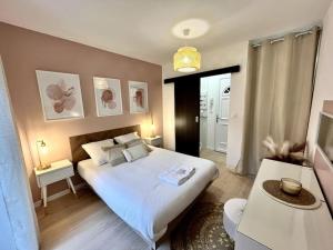 um quarto com uma grande cama branca e duas mesas em Superbe appartement au Centre ville/Balcon em Valence