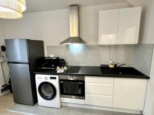 eine Küche mit einem Kühlschrank und einer Waschmaschine in der Unterkunft Superbe appartement au Centre ville/Balcon in Valence + 20 Fotos