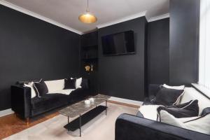 a black living room with a couch and a table at Victoria House in Leeds